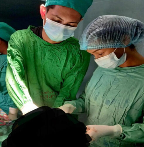 two doctors performing surgery in operating room